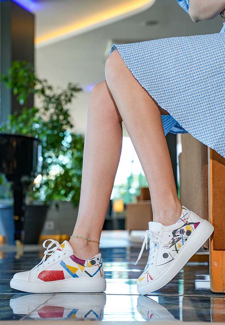 Person wearing colorful sneakers with a blurred indoor background